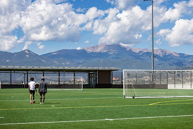 UCCS students on field with Pikes Peak in background