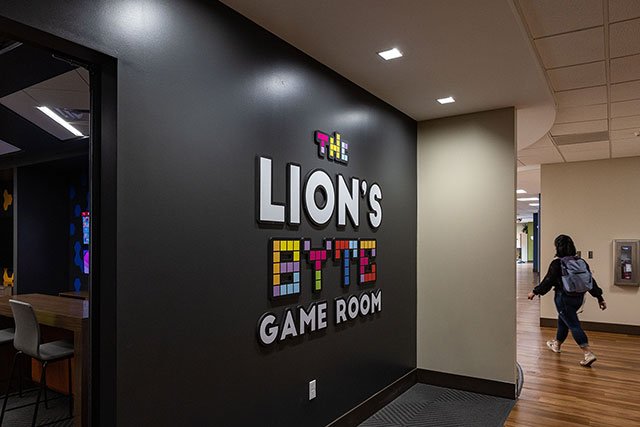 UCCS student walking by Lions Byte Game Room