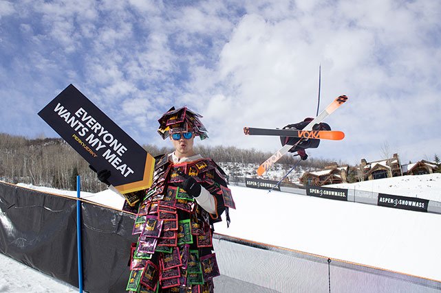 Perky Jerky Jerkman holding sign with skiier in background